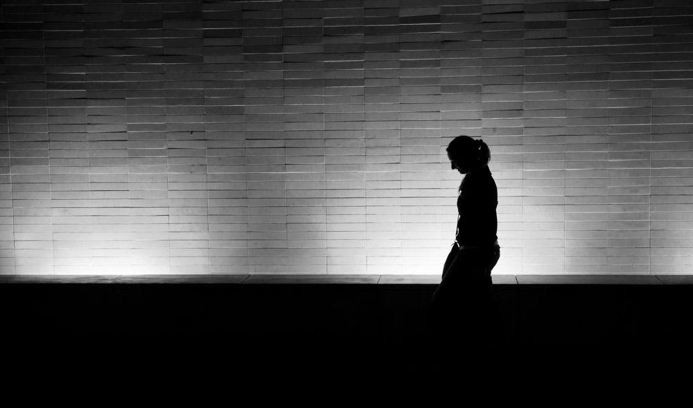 Low light silhouette shot of woman walking