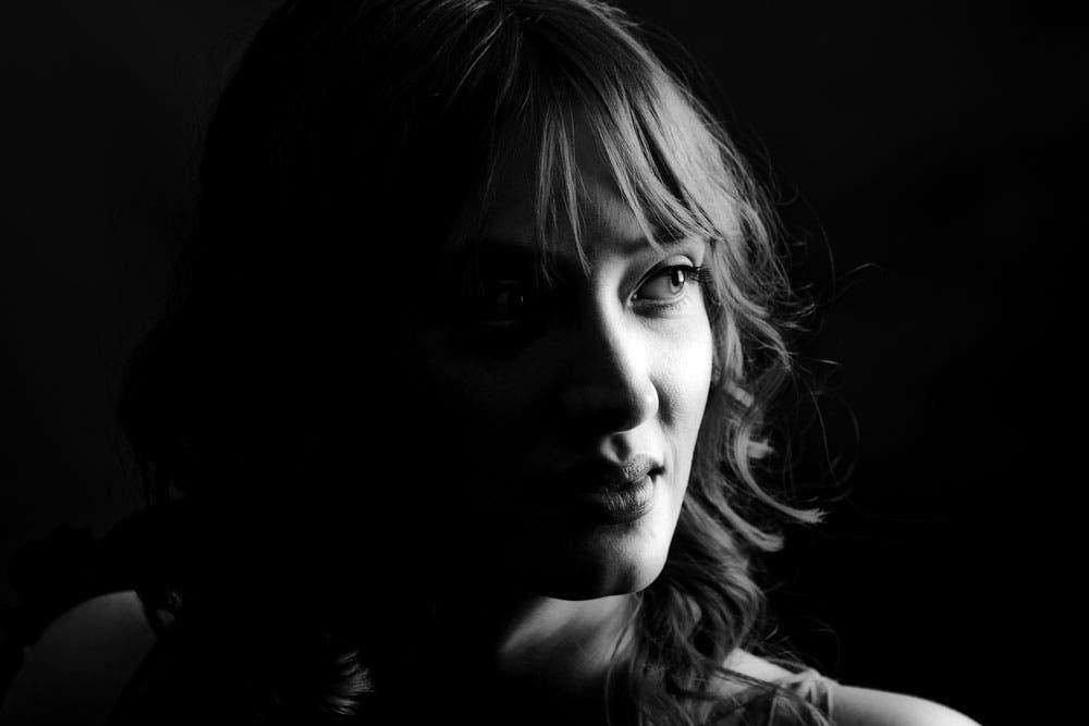 Dramatic low key split light portrait of woman