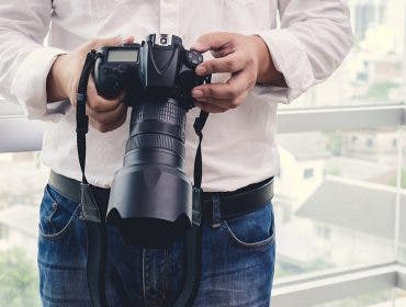 man holding camera with lens