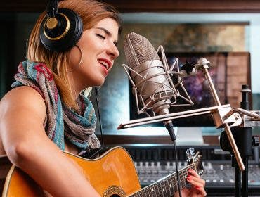 girl singing with guitar recording studio