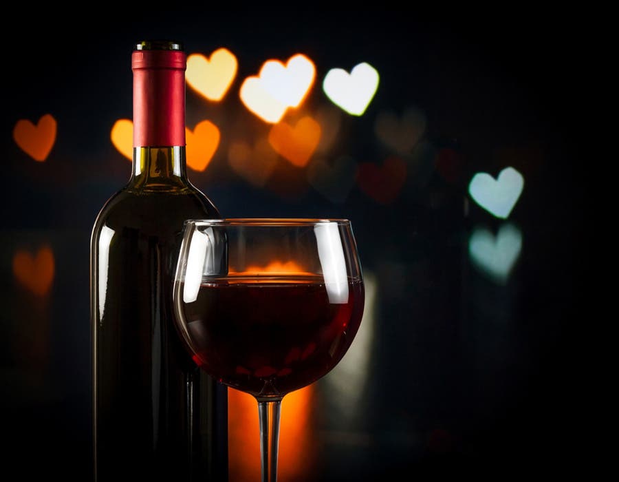 Photo of wine bottle and glass with background bokeh hearts