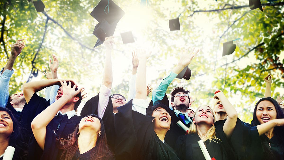 graduation students throwing caps