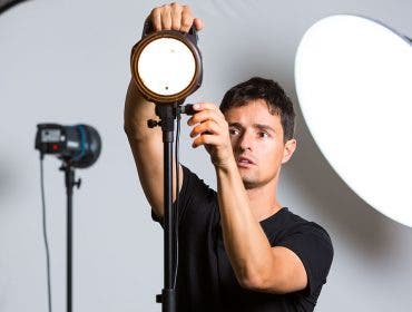 photographer adjusting studio lighting equipment
