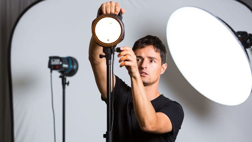 photographer adjusting studio lighting equipment