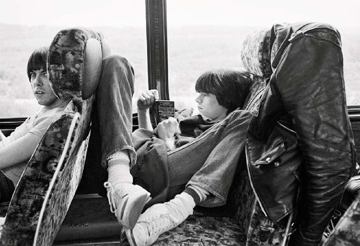 Johnny Ramone sits in front of Dee Dee as he reads on book while on tour in France. Apparently they shared this bus with The Talking Heads. Photo courtesy of Danny Fields.
