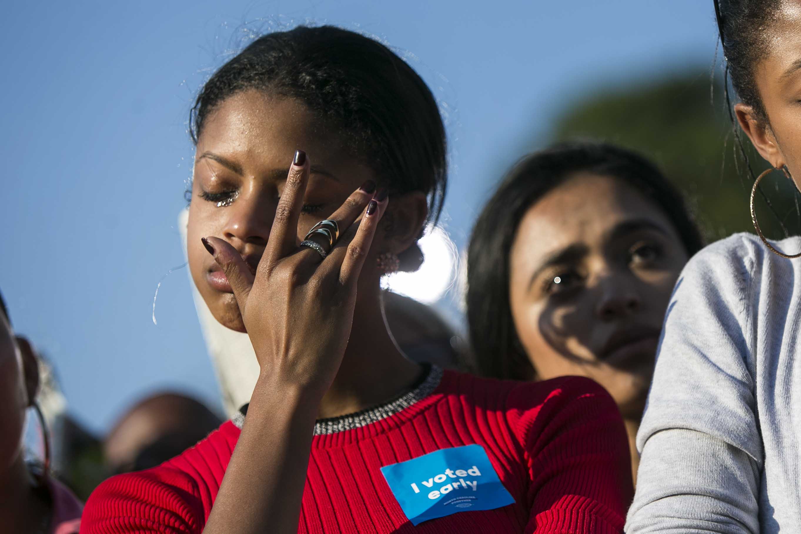 Robyn Sanders, of Cary, N.C., wipes away a tear as she listens with her sister, Ashlyn, as President Barack Obama speaks at a campaign event for Democratic presidential candidate Hillary Clinton, as he promotes early voting, at the University of North Carolina at Chapel Hill, in Chapel Hill, N.C., Wednesday, Nov. 2, 2016. (Al Drago/The New York Times)