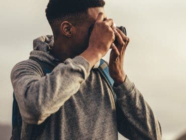 travel photographer capturing sunset with camera