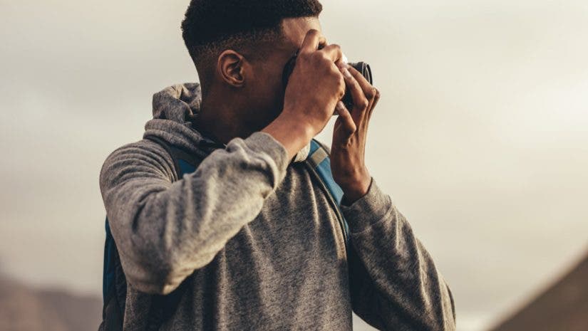 travel photographer capturing sunset with camera