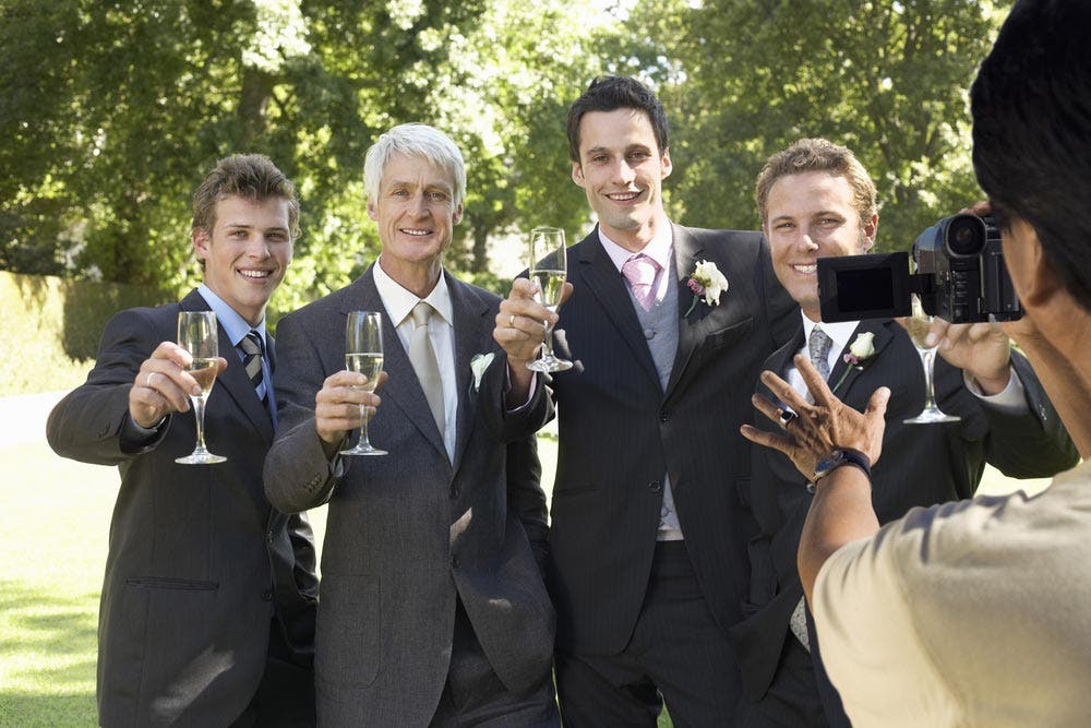 Wedding Photographer Directing Groomsmen For Photo