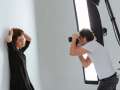 photographer shooting portrait of model in studio