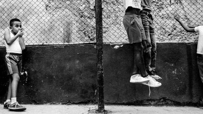 child watching his playmates street photography
