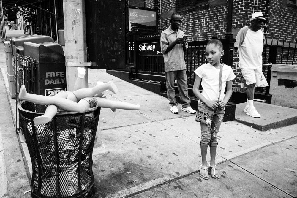girl looking at broken dolls street photography