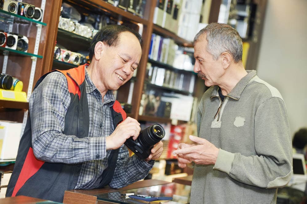 Seller Demonstrating Camera Functions for Buyer