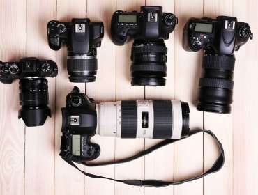 Cameras and Lenses on Wooden Surface