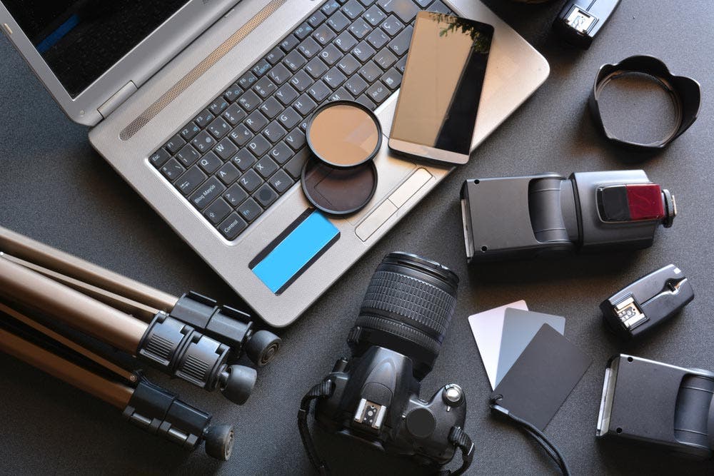 Assorted Camera Equipment Beside Laptop Keyboard