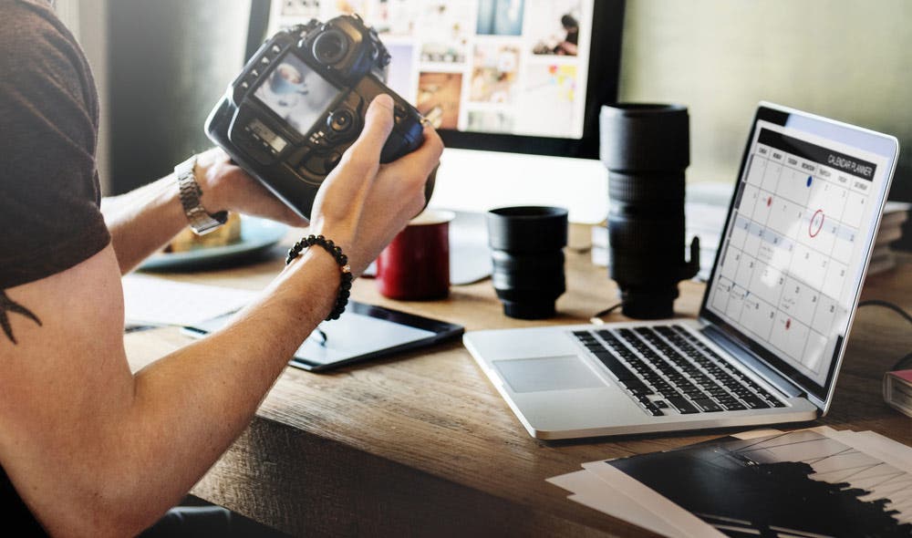 Camera Owner with Gear and Laptop