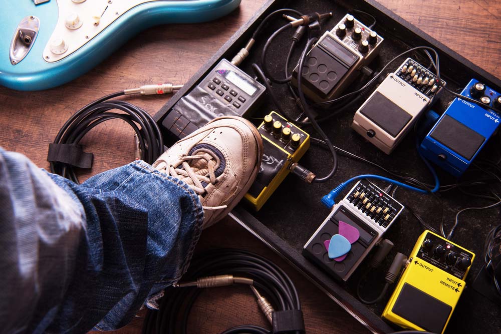 Guitarist Using Guitar Effects Pedals on Pedalboard