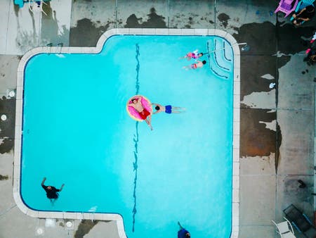 people swimming in pool drone photography