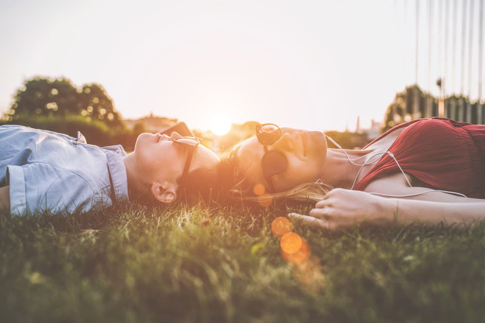 A man and a woman laying on the grass