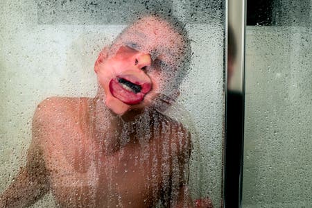 young boy pressing his lips against the glass