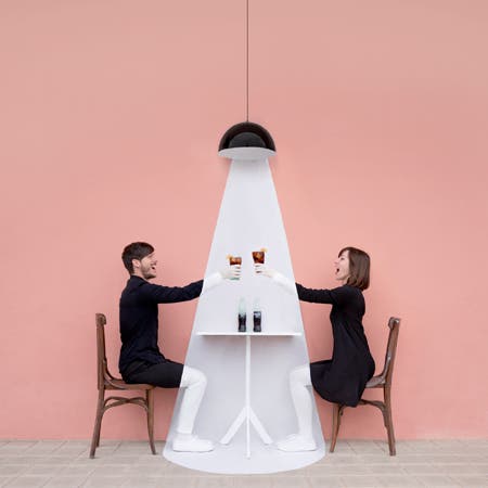 man and woman drinking cola in front of pink background