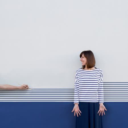 woman wearing blue striped shirt with striped wall background