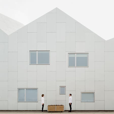 man and woman standing in front of white building