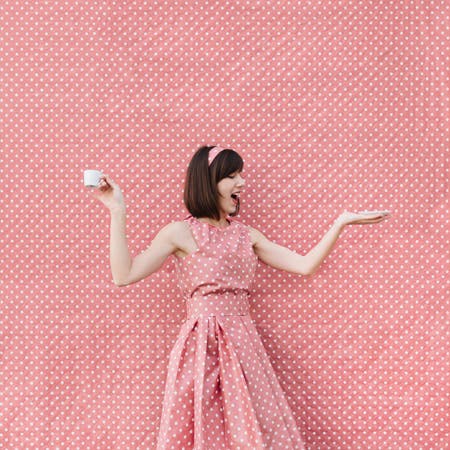 woman wearing pink polka dot dress like background