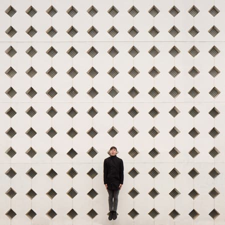 man standing in front of wall with geometric design