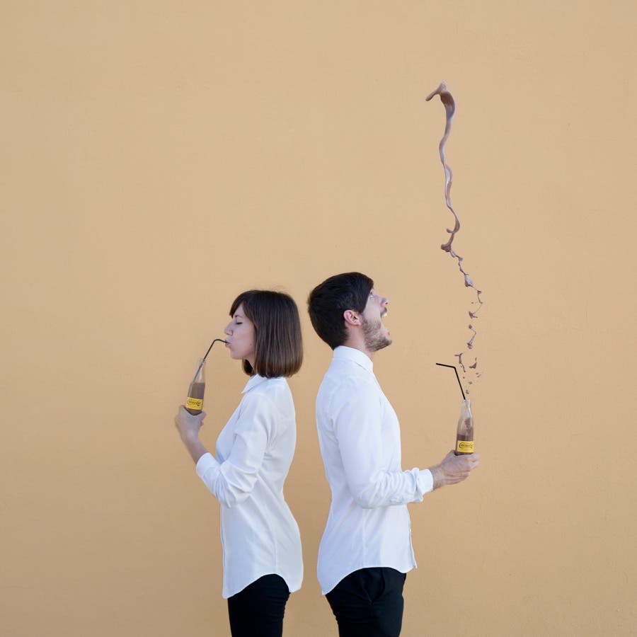 woman and man enjoying chocolate drink in front of brown background