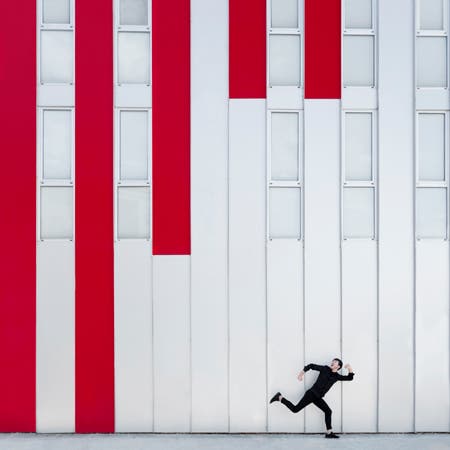 man running in front of wall with red paint