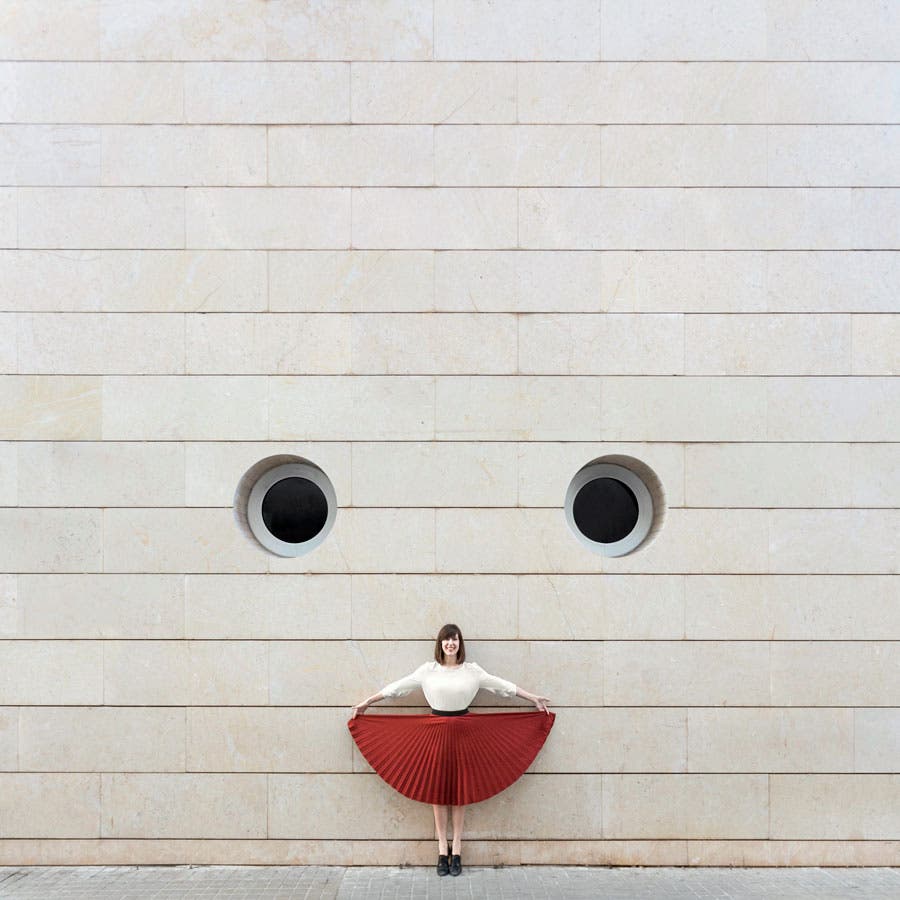 woman in red pleated skirt in front of a wall