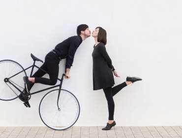man on bicycle trying to kiss woman
