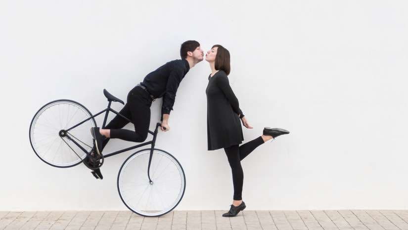 man on bicycle trying to kiss woman