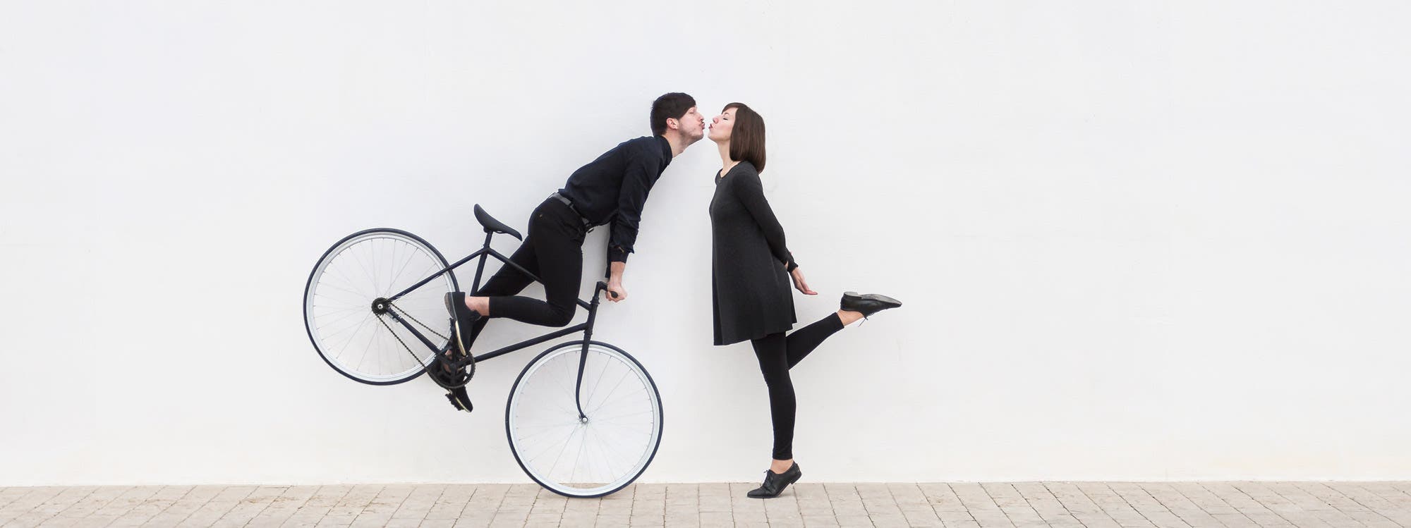 man on bicycle trying to kiss woman