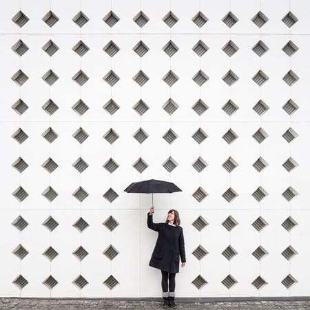 woman standing in front of wall with geometric design