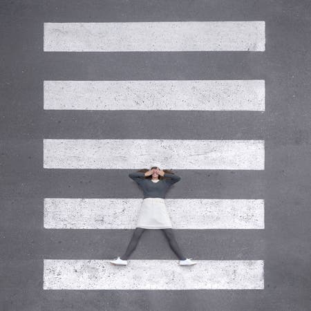 woman lying on pedestrian walkway