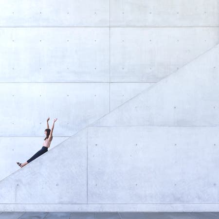 woman sliding down a white stone structure