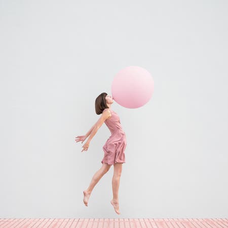 woman blowing pink bubble
