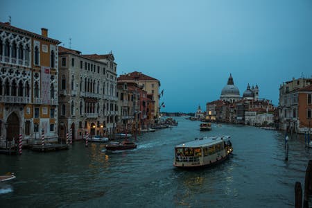 boats traveling down the canal in venice travel photography