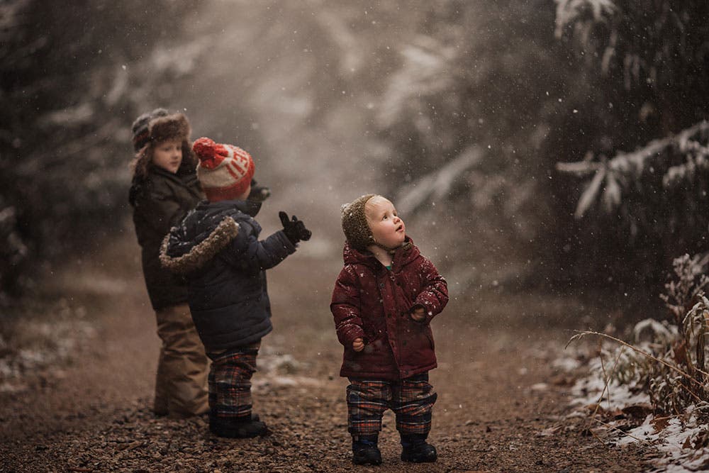 Three young boys enjoying snowfall