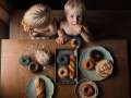 two young boys eating donuts at the table