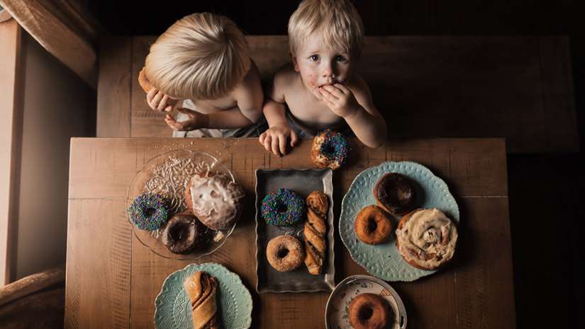 two young boys eating donuts at the table