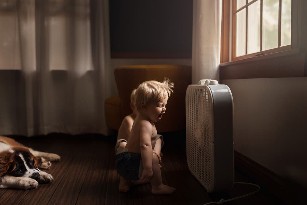 two young boys playing with the fan