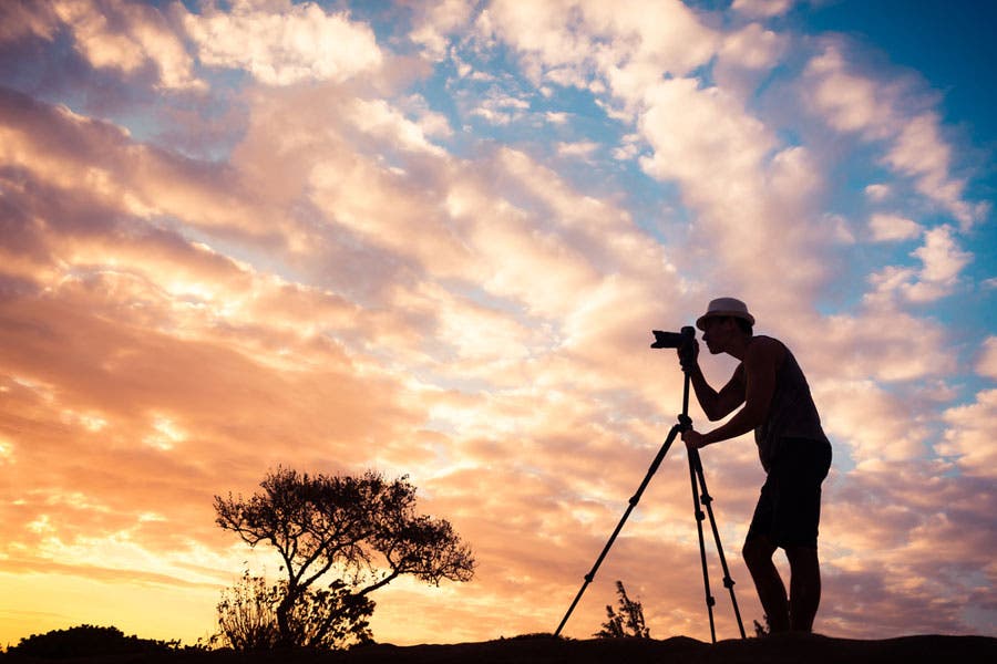 Photographer silhouetted against beautiful cloudy sky