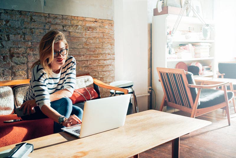 woman sitting in the living room using laptop