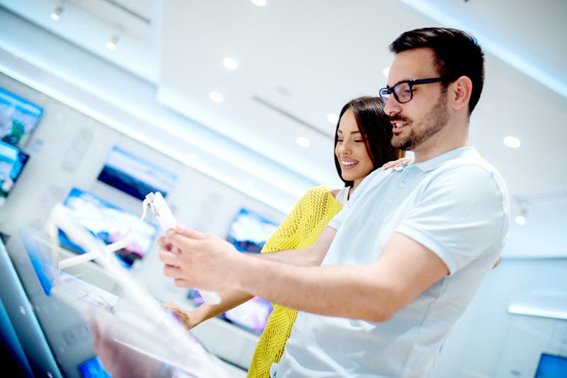 couple comparing gadgets in electronics store