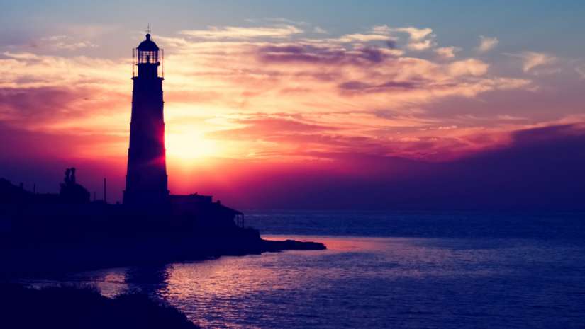 lighthouse by the sea during sunset