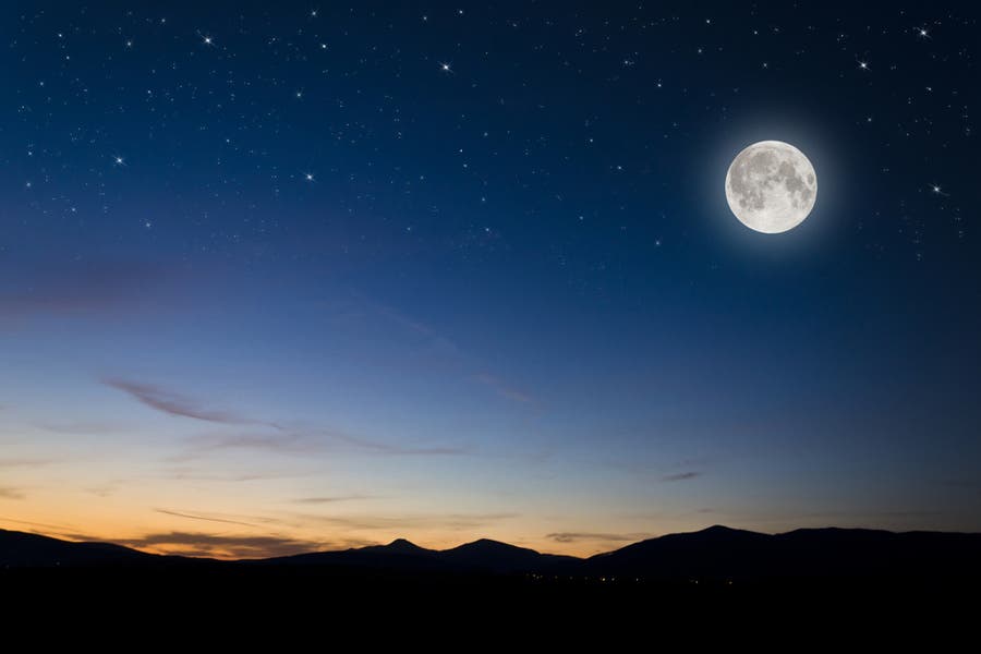 Landscape shot of moon and silhouetted mountain