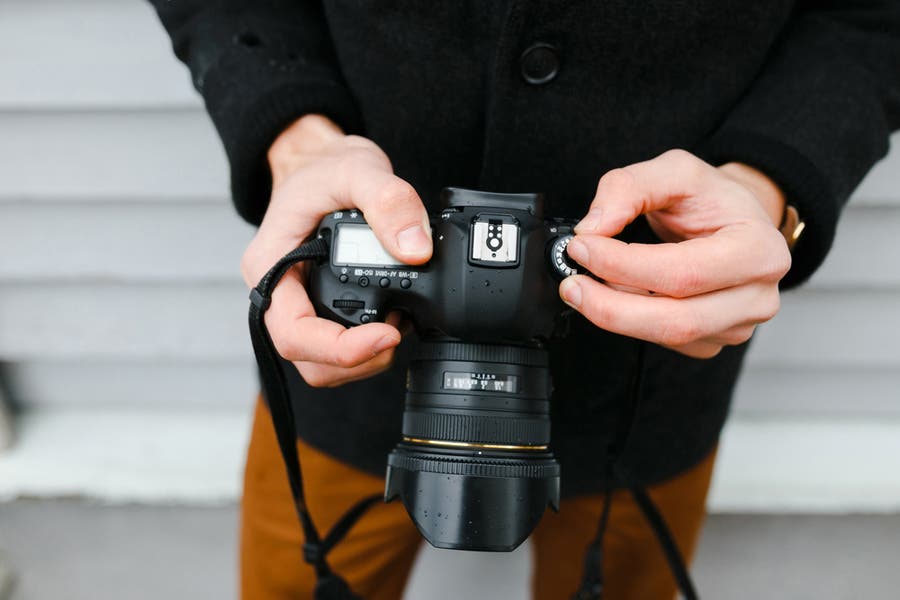 man holding a DSLR camera for street photography